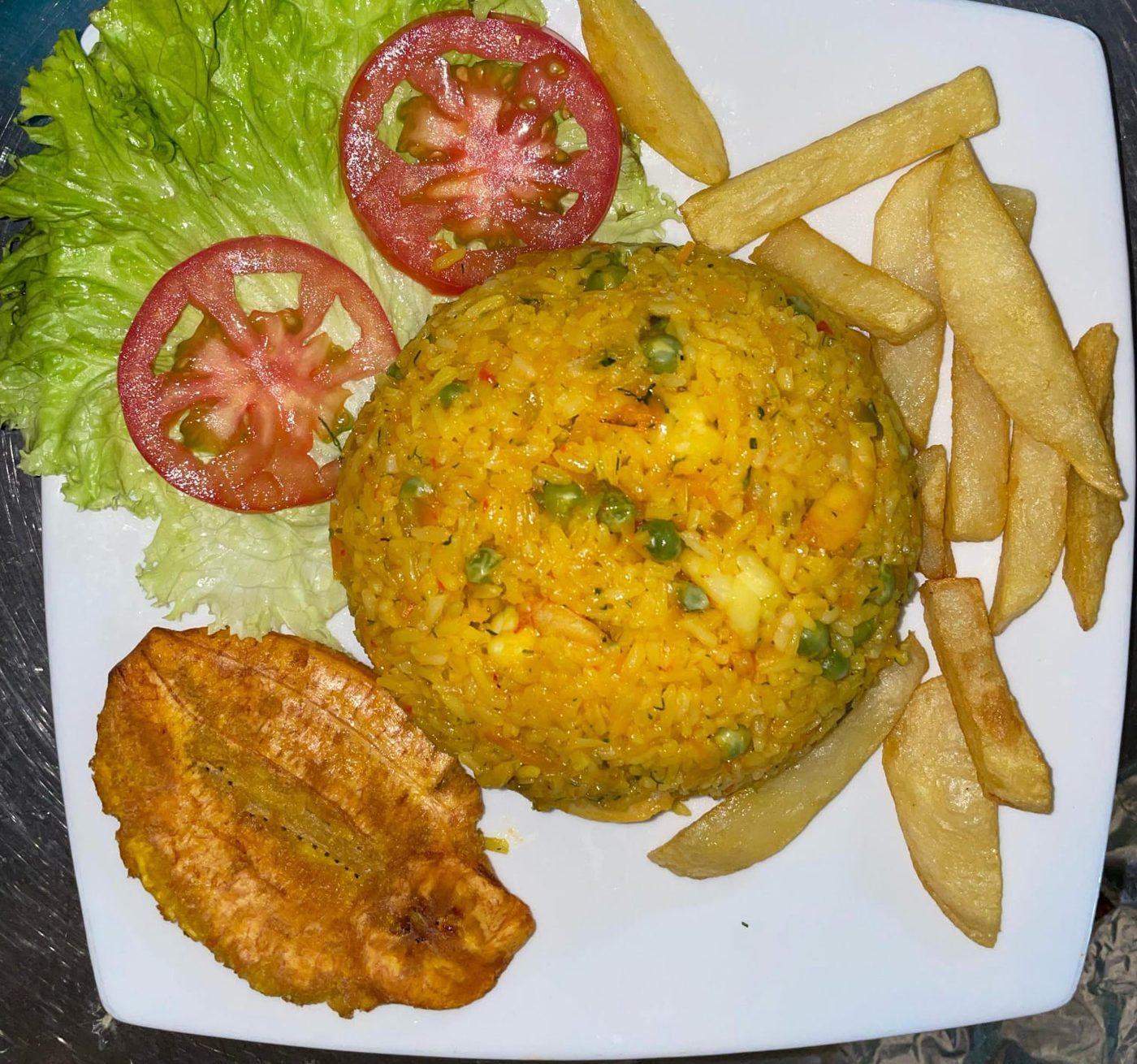 Arroz con camarón acompañado de patacón y papa a la francesa