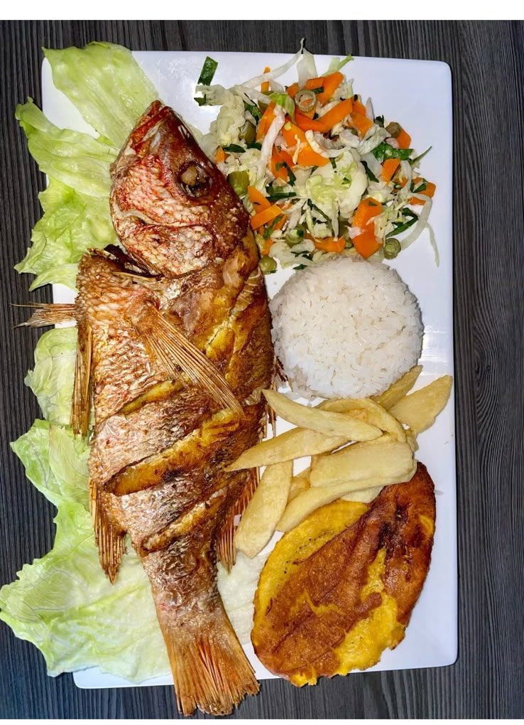 Pargo rojo frito servido con arroz, ensalada, patacón y yuca